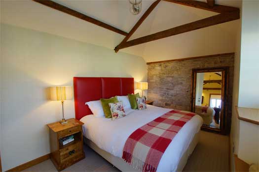 Super king bedroom at The Dairy with exposed beams and quality linens