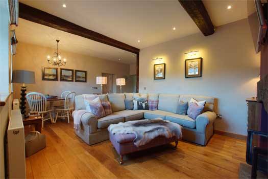 Open-plan living area at The Cottage with wood-burning stove
