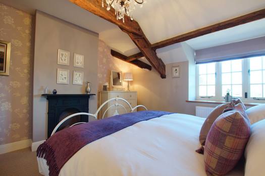 Super-king bedroom at The Cottage beneath exposed beams